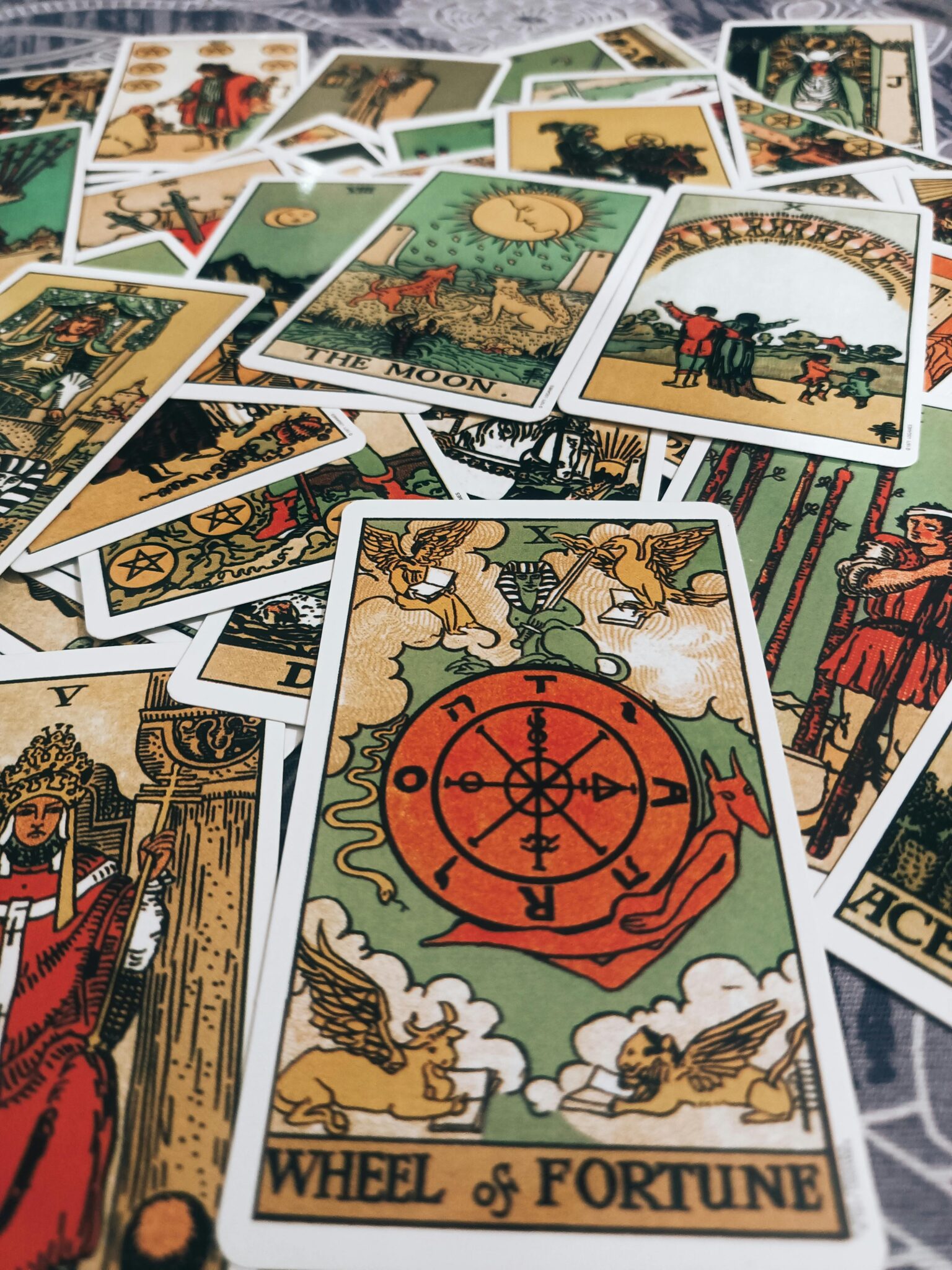 A flat lay of tarot cards including the Wheel of Fortune and other major arcana.