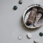 Flat lay of sage bundles and gemstones in an abalone shell for spiritual rituals.